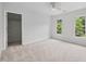 Spacious, carpeted bedroom with ceiling fan, walk-in closet, and backyard views through two windows at 104 S Crabtree Knl, Chapel Hill, NC 27514