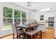 Dining area with hardwood floors, large windows, stylish table seating, and seamless connection to the kitchen at 104 S Crabtree Knl, Chapel Hill, NC 27514