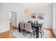 Bright dining room with a modern chandelier, large window, and a dark wood table set for six at 104 S Crabtree Knl, Chapel Hill, NC 27514