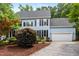Charming two-story home with a manicured lawn, a two-car garage, and an inviting blue facade at 104 S Crabtree Knl, Chapel Hill, NC 27514
