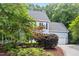 Side view of a charming home with lovely landscaping, healthy trees, and a paved driveway at 104 S Crabtree Knl, Chapel Hill, NC 27514