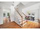 Bright foyer featuring hardwood floors, a staircase with wood handrail, and an adjacent dining room at 104 S Crabtree Knl, Chapel Hill, NC 27514