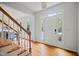 Welcoming foyer with hardwood floors, a staircase with wood handrail, and a front door window at 104 S Crabtree Knl, Chapel Hill, NC 27514