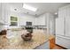 Bright kitchen with white cabinets, stainless steel appliances, granite countertops, recessed lighting, and a breakfast bar area at 104 S Crabtree Knl, Chapel Hill, NC 27514
