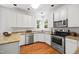 Efficient kitchen with white cabinetry, granite countertops, stainless steel appliances, and hardwood floors, perfect for cooking at 104 S Crabtree Knl, Chapel Hill, NC 27514