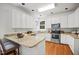 Well-lit kitchen features granite countertops, white cabinets, stainless steel appliances, and hardwood flooring at 104 S Crabtree Knl, Chapel Hill, NC 27514
