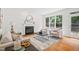 Bright living room featuring a fireplace, hardwood floors, neutral walls, and two comfortable chairs near a sun-drenched window at 104 S Crabtree Knl, Chapel Hill, NC 27514