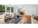 Sun-filled living area featuring hardwood floors, large windows, neutral walls, a stylish rug and comfortable seating at 104 S Crabtree Knl, Chapel Hill, NC 27514