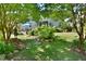 Landscaped backyard featuring a patio with an umbrella table and bench seating, surrounded by lush greenery at 1056 Evening Shade Ave, Rolesville, NC 27571