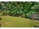Backyard featuring green grass, trees, wooden fence and landscaped border at 1056 Evening Shade Ave, Rolesville, NC 27571