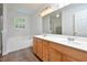 Bright bathroom with double vanity, a soaking tub, and natural light from a window at 1056 Evening Shade Ave, Rolesville, NC 27571