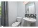 Powder room with pedestal sink, decorative mirror, and patterned accent tiles at 1056 Evening Shade Ave, Rolesville, NC 27571