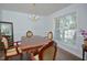 Formal dining room with hardwood floors, chandelier, and views of the greenery outside the window at 1056 Evening Shade Ave, Rolesville, NC 27571
