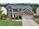 Charming brick two-story home with a two-car garage, manicured lawn, and mature landscaping at 1056 Evening Shade Ave, Rolesville, NC 27571