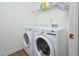 Laundry room with front load washer and dryer with white walls and wood look floor at 1056 Evening Shade Ave, Rolesville, NC 27571