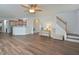 Open living space with hardwood floors, ceiling fan, and staircase leading to the second floor at 1056 Evening Shade Ave, Rolesville, NC 27571