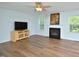 Comfortable living room featuring a fireplace, a ceiling fan, hardwood floors and large windows at 1056 Evening Shade Ave, Rolesville, NC 27571