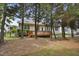 Backyard showcasing a wooden deck, fenced perimeter, and the rear of the house amid lush trees at 107 Governors House Dr, Morrisville, NC 27560