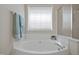 Bright bathroom with white cabinetry, a large soaking tub, and a glass enclosed shower at 107 Governors House Dr, Morrisville, NC 27560