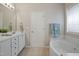 Bright bathroom featuring a bathtub, white vanity with double sinks and a framed mirror at 107 Governors House Dr, Morrisville, NC 27560