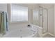 Bright bathroom featuring a soaking tub, tiled floors and glass enclosed shower at 107 Governors House Dr, Morrisville, NC 27560