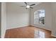 Bedroom with wood floors, a ceiling fan, and a large window providing neighborhood views at 107 Governors House Dr, Morrisville, NC 27560