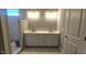 Bathroom featuring double vanity, walk-in shower with grey tile, and a door at 109 Drew St, Louisburg, NC 27549