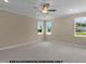 Large bedroom with three large windows, a ceiling fan, carpet, and neutral paint at 109 Drew St, Louisburg, NC 27549