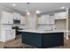 Modern kitchen featuring stainless steel appliances, white cabinets, a large island, and pendant lighting at 109 Drew St, Louisburg, NC 27549