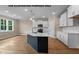 Spacious kitchen featuring an island, stainless steel appliances, white cabinets, and hardwood flooring at 109 Drew St, Louisburg, NC 27549