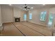 Bright living room featuring a fireplace, large windows, and a ceiling fan at 109 Drew St, Louisburg, NC 27549