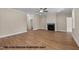 Open concept living room with a fireplace, hardwood flooring, ceiling fan, and natural lighting at 109 Drew St, Louisburg, NC 27549