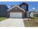 Charming two-story home with a two-car garage and brick accents under a clear blue sky at 109 Gabriel Ct, Wilson's Mills, NC 27520