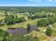Panoramic aerial view of a lush golf course with lake in a residential neighborhood at 113 Feezor Ct, Clayton, NC 27527