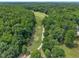 An aerial view of a beautiful golf course surrounded by lush green trees and manicured fairways at 113 Feezor Ct, Clayton, NC 27527