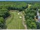 An aerial view showcases the beautiful golf course, surrounded by lush green trees and manicured fairways at 113 Feezor Ct, Clayton, NC 27527