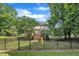 Spacious fenced backyard with a play set and a deck, offering privacy and space for recreation at 113 Feezor Ct, Clayton, NC 27527