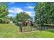 Fenced backyard features mature trees, a wooden deck, and a play set at 113 Feezor Ct, Clayton, NC 27527