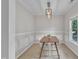 Bright dining room featuring modern lighting, stylish wainscoting, and a view to the garden at 113 Feezor Ct, Clayton, NC 27527