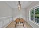 Bright dining room featuring modern lighting, stylish wainscoting, and a view to the garden at 113 Feezor Ct, Clayton, NC 27527