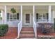 Inviting front porch with brick steps and a hanging fern, creating a cozy entrance at 113 Feezor Ct, Clayton, NC 27527