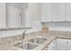 Kitchen sink with stone countertops, white cabinets, and stainless faucet at 113 Feezor Ct, Clayton, NC 27527