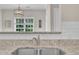 Close-up of a stainless steel kitchen sink with granite countertops and a bright window view at 113 Feezor Ct, Clayton, NC 27527