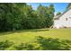 Spacious backyard featuring a well-maintained lawn, mature trees and landscaping at 120 Tanager Farms Dr, Youngsville, NC 27596