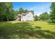 Open backyard with lush lawn and mature shade trees offers room for recreation at 120 Tanager Farms Dr, Youngsville, NC 27596