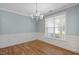 Elegant dining room featuring wood floors, classic wainscoting, and a stylish chandelier at 120 Tanager Farms Dr, Youngsville, NC 27596