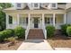 Inviting front entrance with covered porch, brick stairs, and manicured landscaping at 120 Tanager Farms Dr, Youngsville, NC 27596