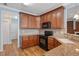 Charming kitchen featuring wooden cabinetry, granite countertops, and modern black appliances at 120 Tanager Farms Dr, Youngsville, NC 27596