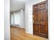 Entryway featuring hardwood floors, white curtains, and a dark wood front door at 1209 Landon St, Durham, NC 27703