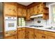 Eat-in kitchen features charming knotty pine cabinets, tiled backsplash, and modern appliances at 1209 Landon St, Durham, NC 27703